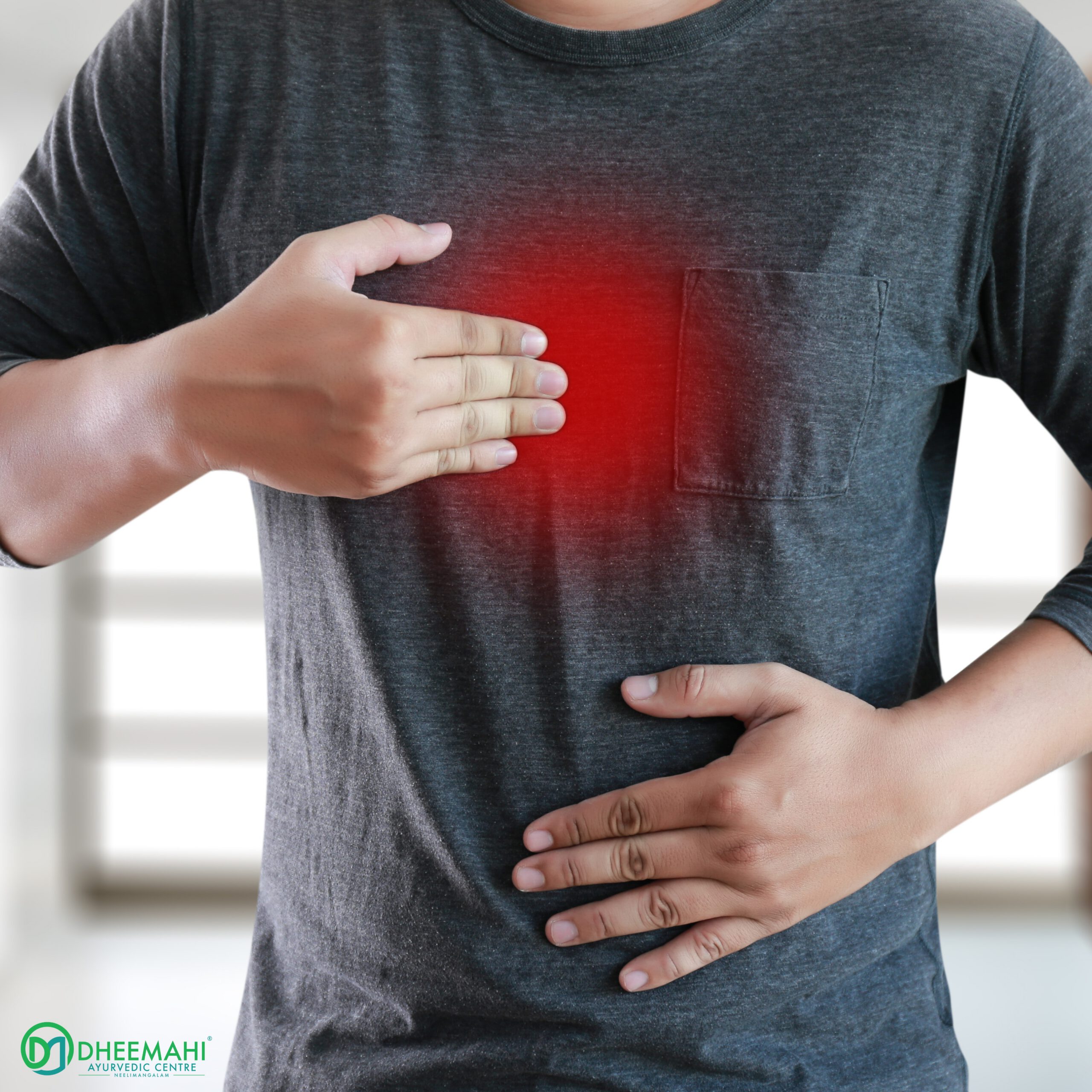 How Ayurveda Heals Gas and Acidity by Balancing Digestion A man in a dark grey shirt is shown holding his chest and stomach, indicating discomfort or pain, with a red highlighted area on the chest suggesting heartburn or acidity. The logo of Dheemahi Ayurvedic Centre is visible in the bottom-left corner.