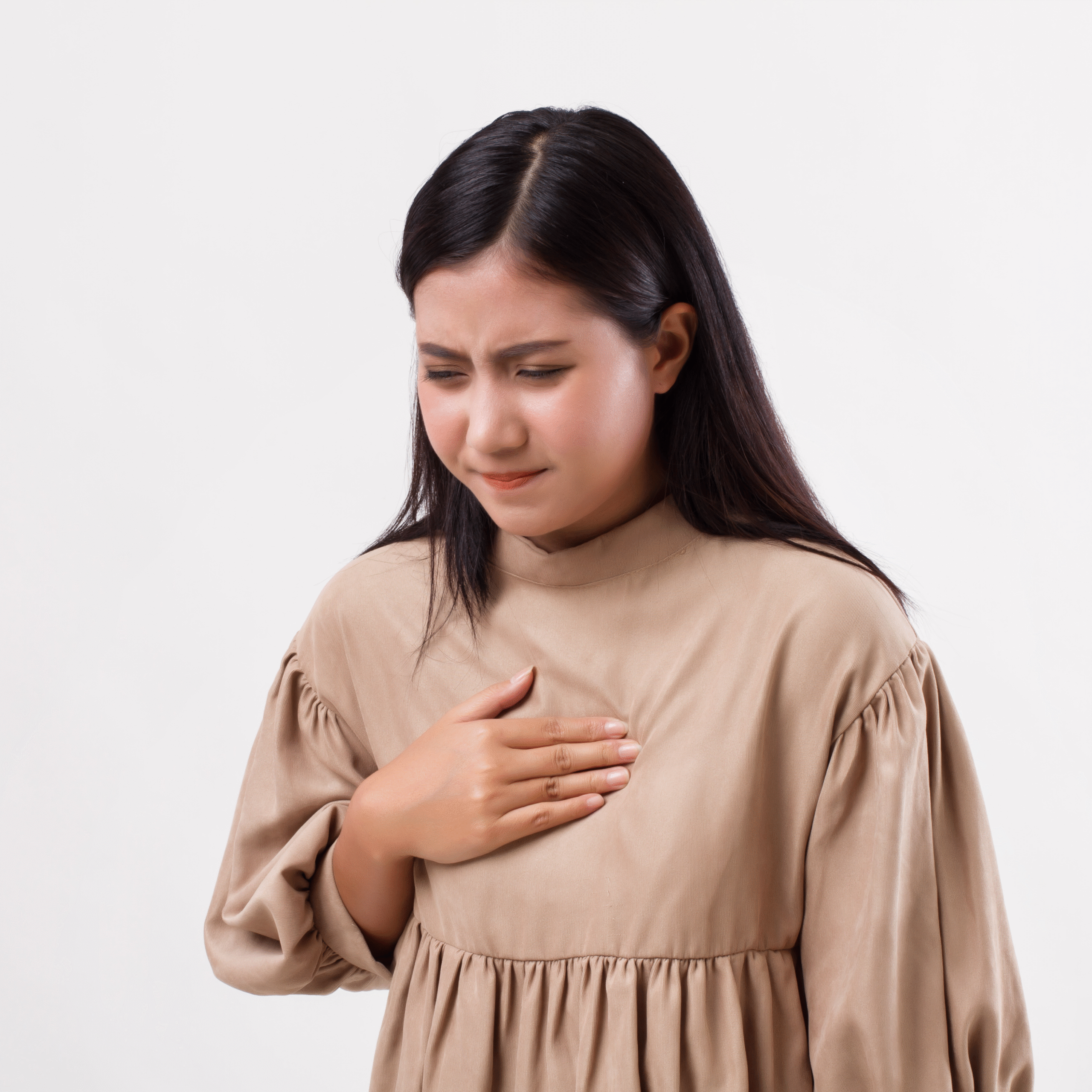 Woman Experiencing GERD Symptoms Woman clutching her chest in discomfort, showing possible signs of GERD or acid reflux.