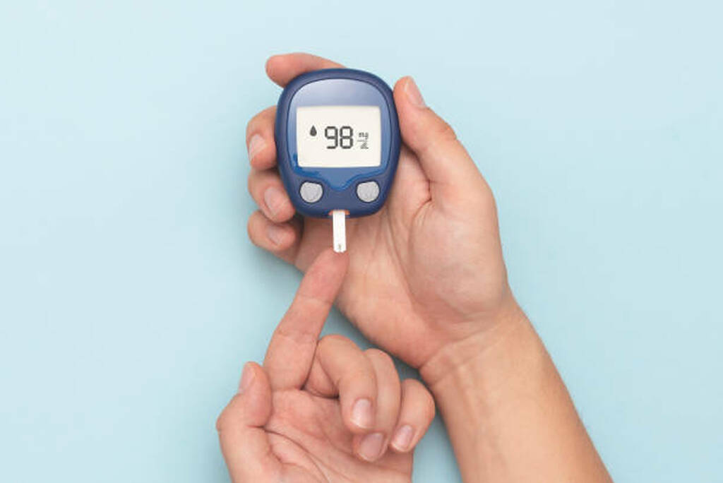 Person checking blood sugar level with a glucometer – concept of Ayurveda treatment for type 2 diabetes.