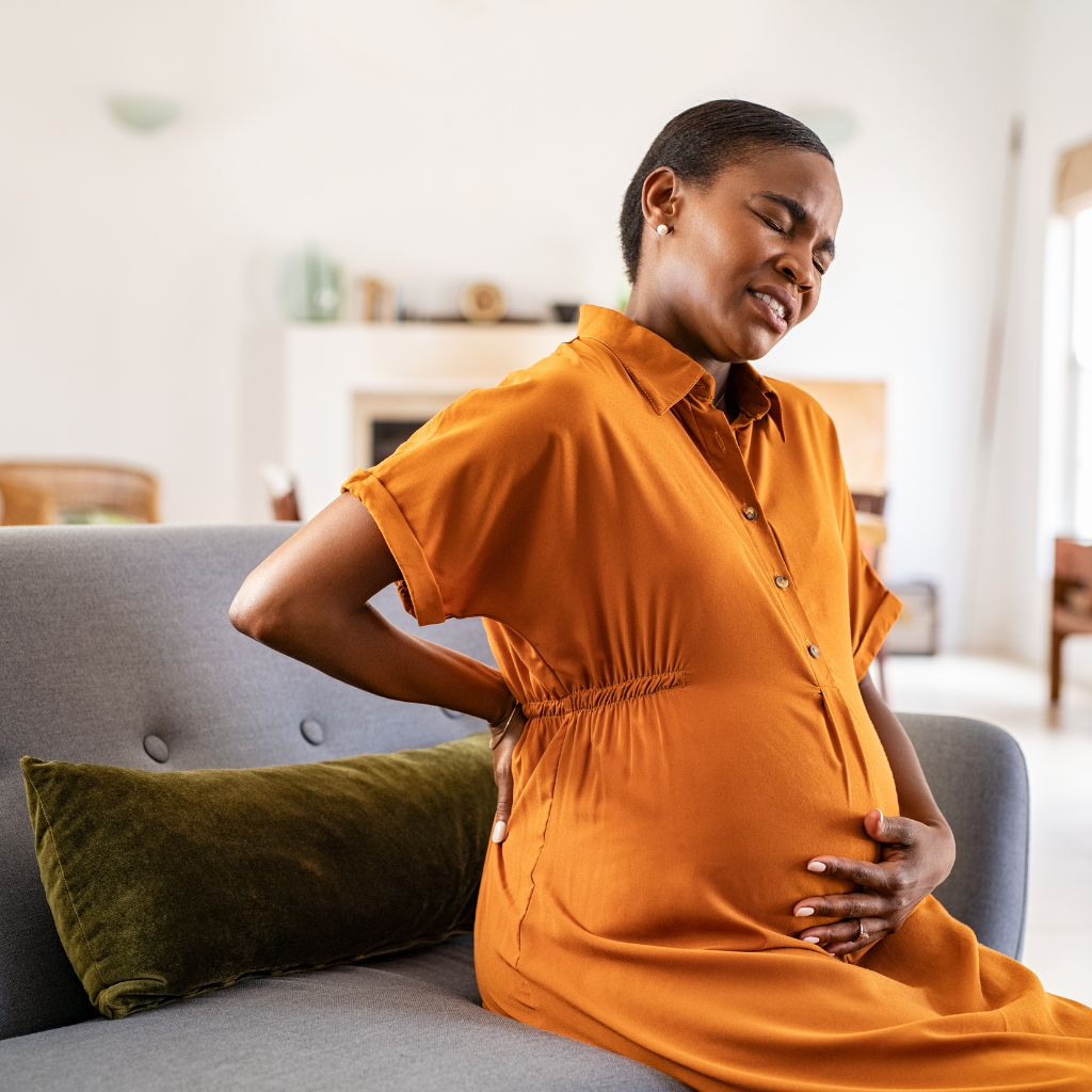 Lower Back Pain During Pregnancy – Common Discomfort in Expecting Mothers Pregnant woman holding her lower back in discomfort representing lower back pain during pregnancy