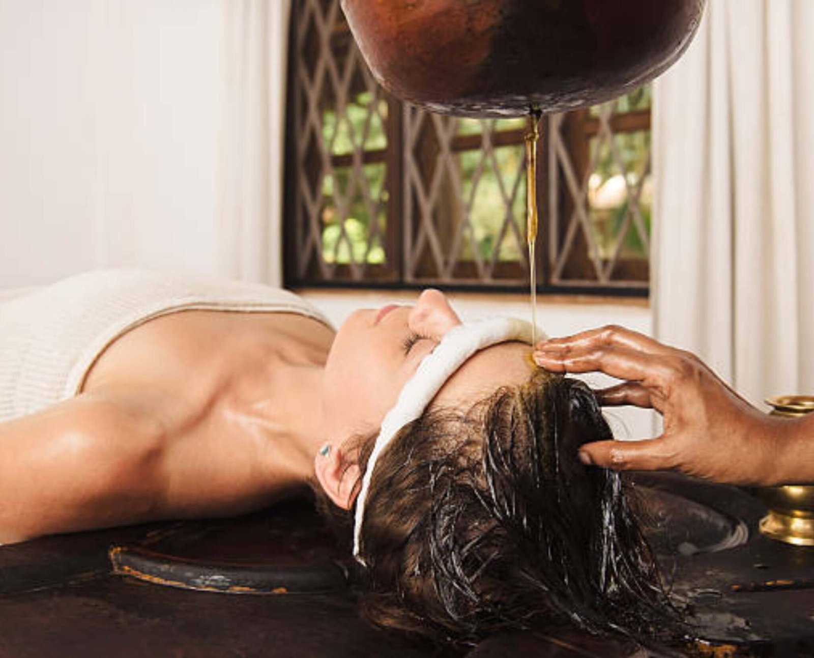 Person receiving Shirodhara therapy as part of Ayurvedic treatment for stress and anxiety at an authentic Ayurveda wellness center in Kerala.