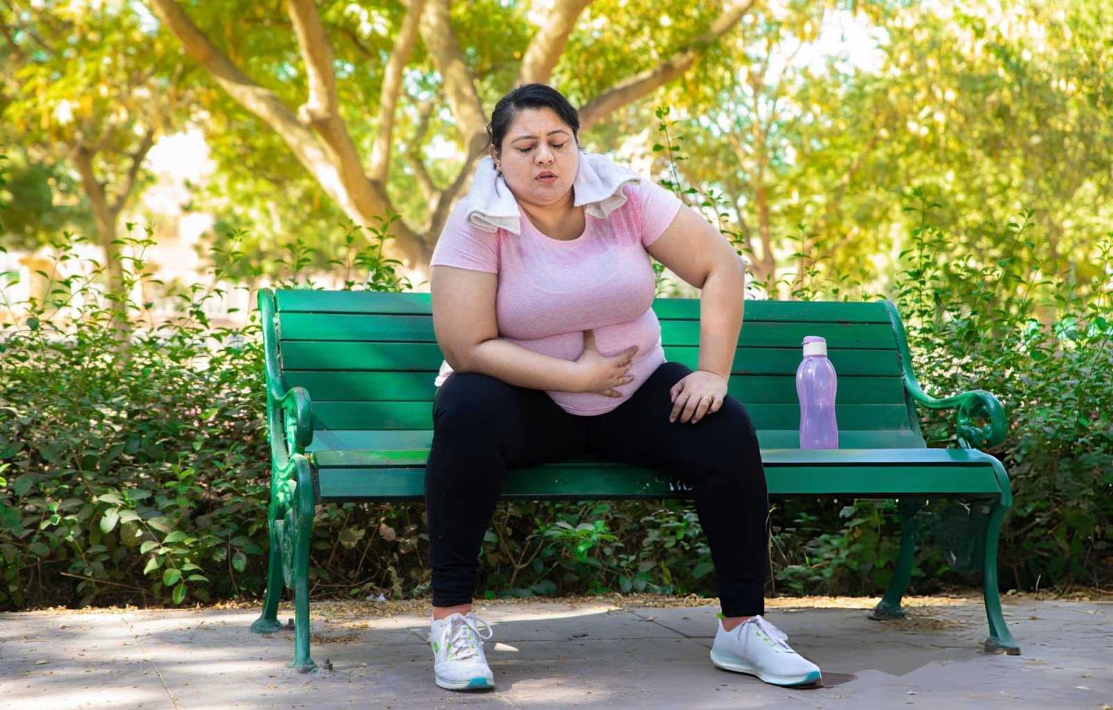 Overweight woman sitting on a park bench after exercise, highlighting the importance of Ayurvedic Weight Loss Treatment in Kerala for managing obesity, improving metabolism, and achieving healthy weight loss naturally.